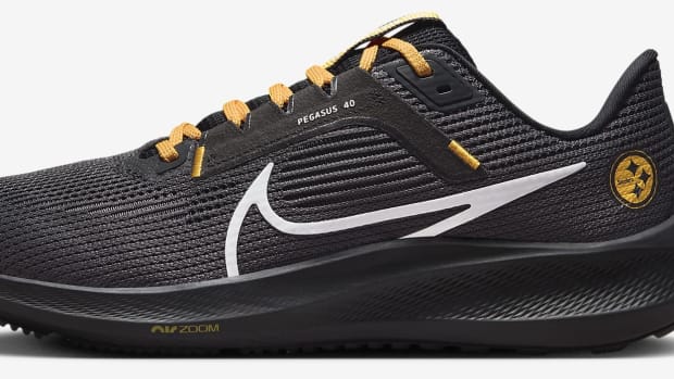 Side view of black and yellow Nike running shoes.